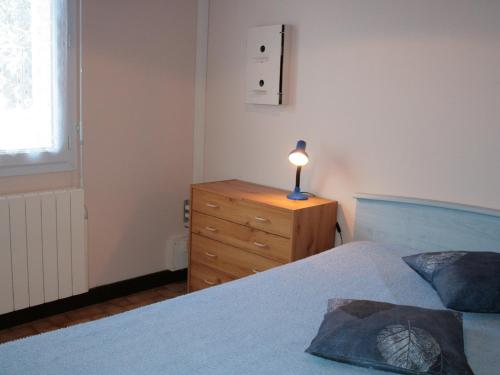 une chambre avec un lit et une lampe sur une commode dans l'établissement Maison Plain-Pied Proche Plage et Commerces à La Tranche-sur-Mer – Idéal Familles - FR-1-22-210, à La Tranche-sur-Mer
