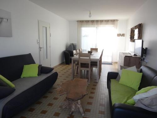 un salon avec deux canapés et une table dans l'établissement Maison confortable près de la plage, au calme, idéale pour des vacances en famille - FR-1-476-101, à La Faute-sur-Mer