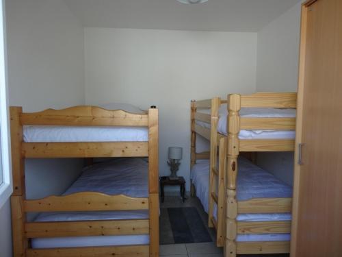 a room with two bunk beds and a door at Maison confortable près de la plage, au calme, idéale pour des vacances en famille - FR-1-476-101 in La Faute-sur-Mer