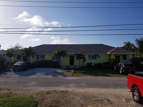 una casa con un coche aparcado delante de ella en Seashells en Nassau