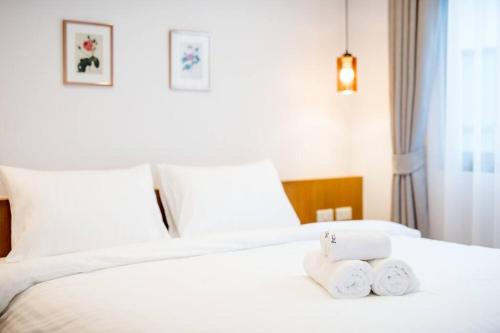a hotel room with a bed with two towels on it at Portrait Huahin in Hua Hin