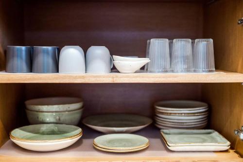 a shelf filled with plates and bowls and dishes at Portrait Huahin in Hua Hin