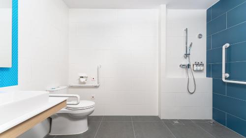 a bathroom with a toilet and a shower at Holiday Inn Express Shunde Daliang by IHG in Shunde
