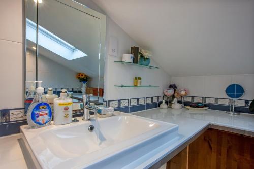 a bathroom with a sink and a mirror at Premium 2nd floor 2 bed Apt sleeps 4 adults in Oban town in Oban