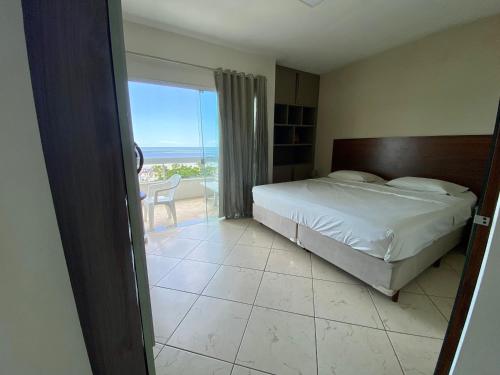 1 dormitorio con cama y vistas al océano en Apartamento com Vista, en Balneário Camboriú