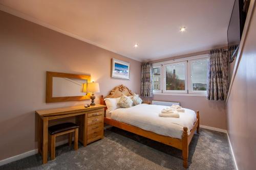 a bedroom with a bed and a desk and a window at Premium 2nd floor 2 bed Apt sleeps 4 adults in Oban town in Oban