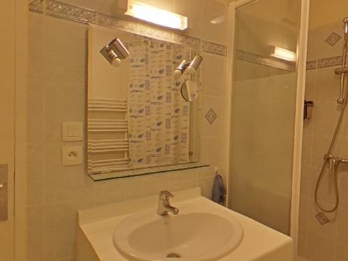 uma casa de banho com um lavatório, um chuveiro e um espelho. em Appartement Saint-Brevin-les-Pins, 2 pièces, 3 personnes - FR-1-364-141 em Saint-Brévin-les-Pins