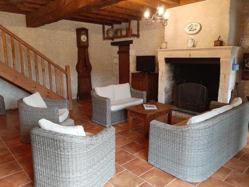 a living room with wicker chairs and a fireplace at Gîte Lignières-Ambleville-Lignières-Sonneville, 4 pièces, 11 personnes - FR-1-653-88 in Lignières-Sonneville