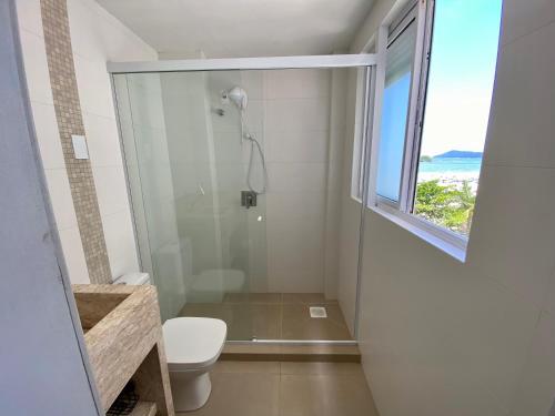 ein Bad mit Dusche, WC und Fenster in der Unterkunft Apartamento Estúdio Vista Mar in Balneário Camboriú