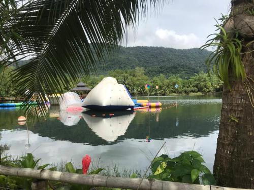 a boat sitting in the water near a palm tree at Bungalow Together in Ban Khanim