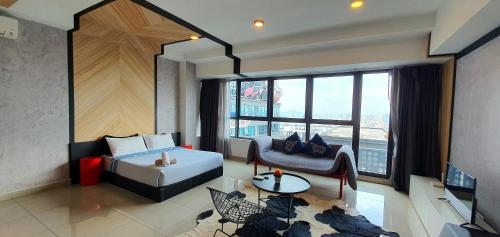 een kamer met een bed, een bank en een tafel bij ARTE+ Jalan Ampang in Kuala Lumpur