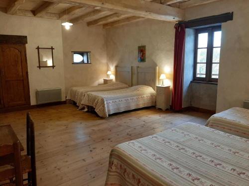 Un dormitorio con tres camas en una habitación. en Ancien Moulin Rénové avec Piscine et Jardin, Idéal Familles, Vignobles du Cognac - FR-1-653-88, en Lignières-Sonneville