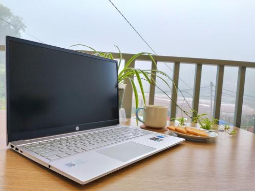 a laptop computer sitting on top of a wooden table at Ng Family’s Farm Stay in Cameron Highlands