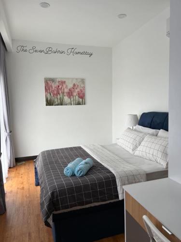 a bedroom with two beds and a picture on the wall at TheSevenBahrin Homestay in Seri Kembangan