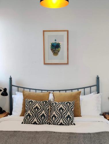 a bed with pillows and a picture on the wall at Ananya Apartments Phase 2 in Kathmandu