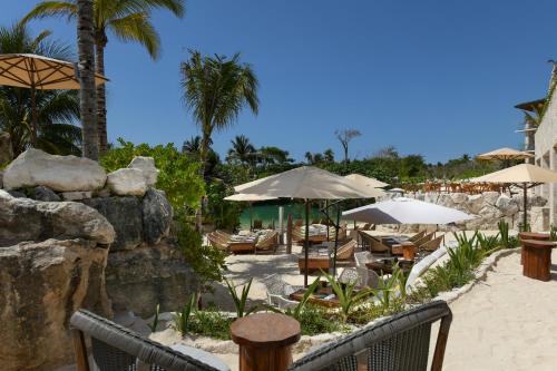 a resort with chairs and umbrellas on the beach at Hotel Xcaret Mexico All Parks All Fun Inclusive in Playa del Carmen