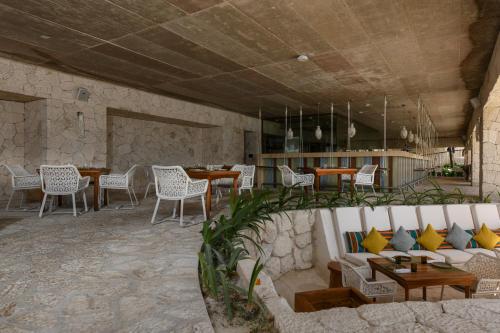 a restaurant with a couch and tables and chairs at Hotel Xcaret Mexico All Parks All Fun Inclusive in Playa del Carmen