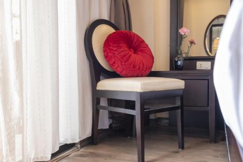 a red pillow sitting on a chair in a desk at Hanoi Center Silk Charming Hotel & Travel in Hanoi