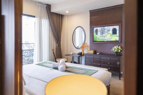 河內的住宿－Hanoi Center Silk Charming Hotel & Travel，一间卧室设有一张大床和一张黄色的桌子。
