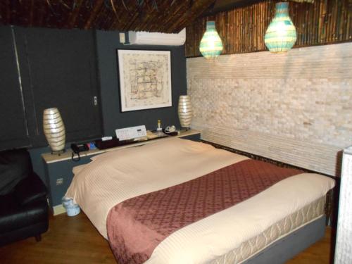 1 dormitorio con 1 cama con pared de ladrillo en Abollo Odawara, en Odawara