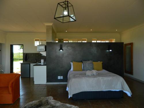 a bedroom with a large bed and a kitchen at Dewdrop Farm Stay in Ermelo