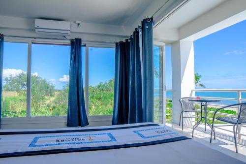 a bedroom with a bed and a balcony at Sailors Beach Fiji in Nadi