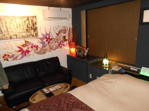 a bedroom with a bed and a couch and a desk at Abollo Odawara in Odawara