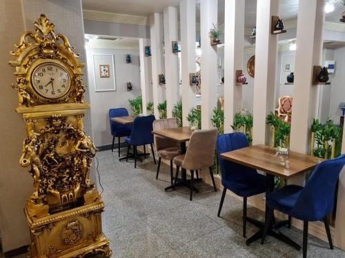 a gold clock in a restaurant with tables and chairs at Hamit Hotel Istanbul in Istanbul