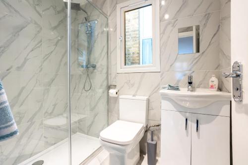 La salle de bains est pourvue de toilettes, d'une douche et d'un lavabo. dans l'établissement Amazing 3bedroom ground floor house with garden and 2 bathrooms, à Londres