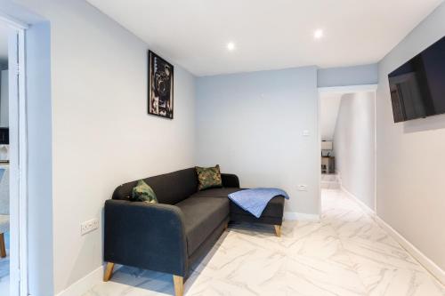 a living room with a couch and a tv at Amazing 3 bedroom, 2 bathroom, ground floor flat with garden, near train Station and bus stop in London