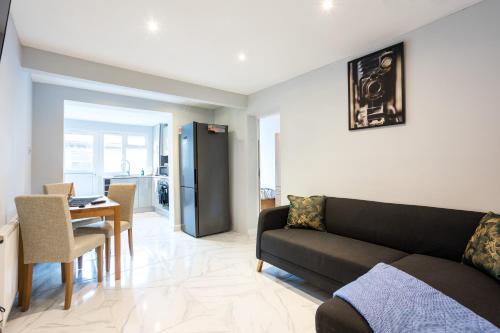 a living room with a couch and a table at Amazing 3 bedroom, 2 bathroom, ground floor flat with garden, near train Station and bus stop in London