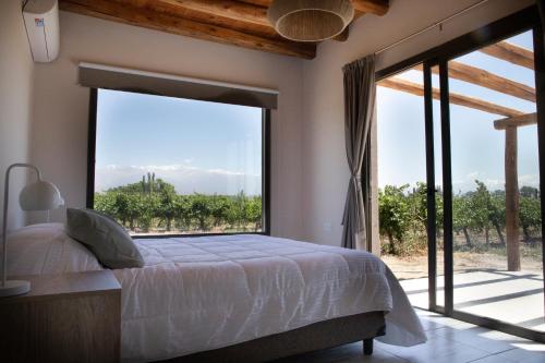 1 dormitorio con cama y ventana grande en Casa Premium - Finca Rosablanca, viña y montaña en Vista Flores