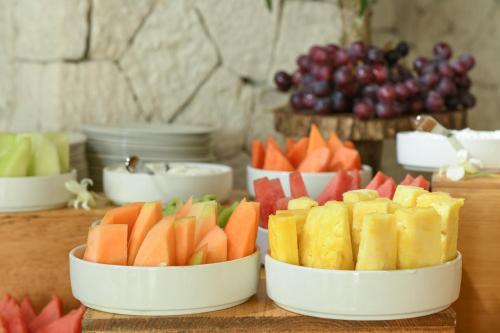 a table topped with bowls of cut up fruit at Hotel Xcaret Arte - All Parks All Fun Inclusive - Adults Only in Playa del Carmen