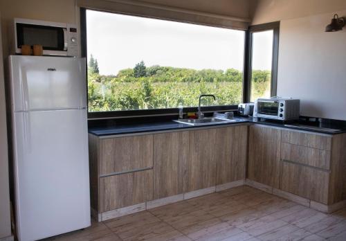 uma cozinha com um frigorífico branco e uma janela em Casa Premium - Finca Rosablanca, viña y montaña em Vista Flores