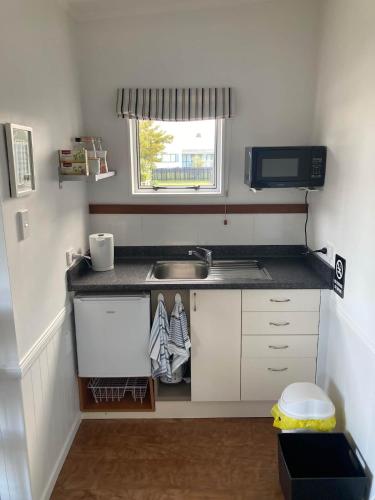 a small kitchen with a sink and a window at Cosy Studio on Hyde in Taupo