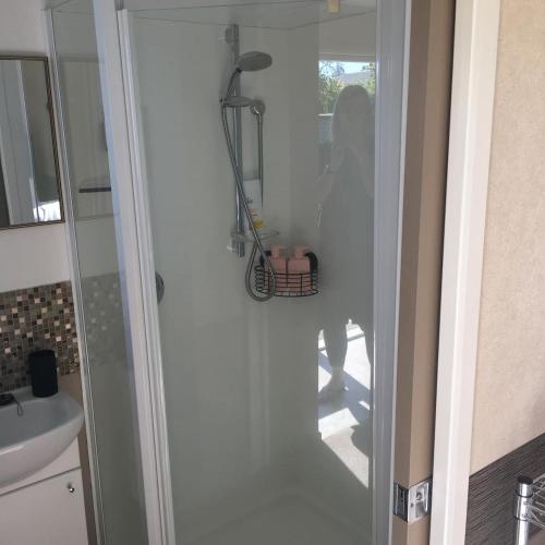 a woman standing in a bathroom with a glass door at Cosy Studio on Hyde in Taupo