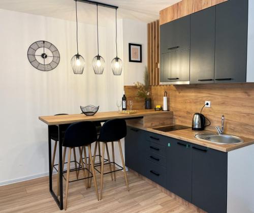a kitchen with black cabinets and a counter with bar stools at Tijana 2 in Pale