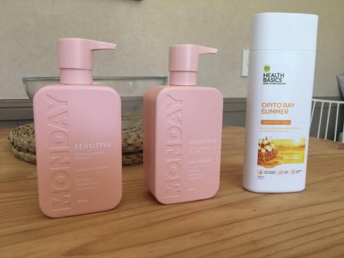 three bottles of shampoo and conditioner sitting on a table at Cosy Studio on Hyde in Taupo