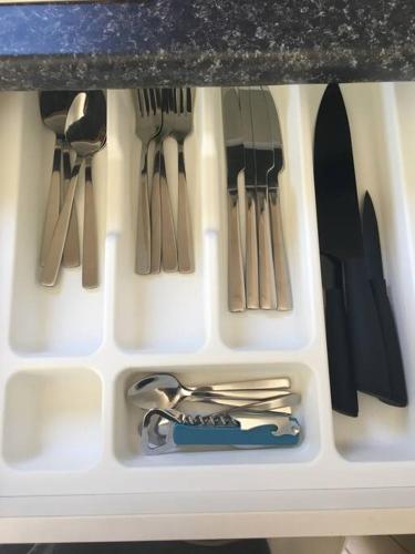 a white tray with utensils in a drawer at Cosy Studio on Hyde in Taupo