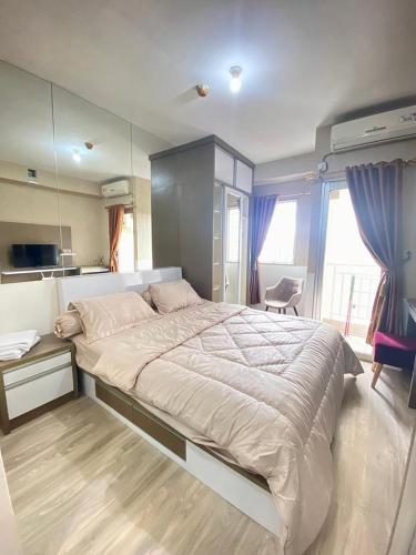 a bedroom with a large bed with a mirror at Apartemen Pakubuwono Terrace Tipe Studio Jakarta in Jakarta