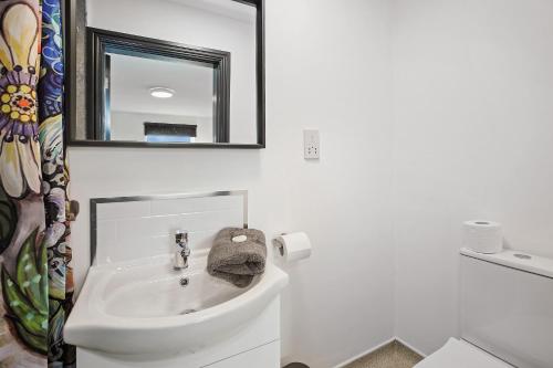 a white bathroom with a sink and a mirror at TYME Coastal Suites-1 and 2 Bedroom in Cleethorpes