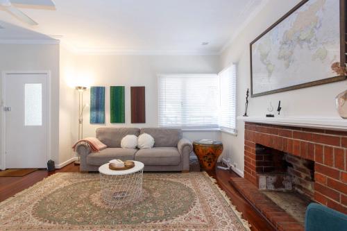 a living room with a couch and a fireplace at Home Away - 2 Bedroom Cottage in Bicton