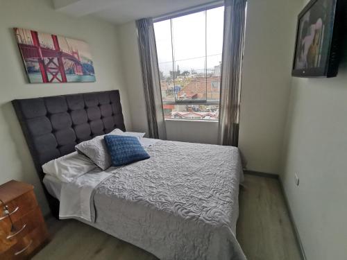 1 dormitorio con 1 cama y ventana grande en Cómodo departamento céntrico y cerca a lugares turísticos de la ciudad, en Arequipa