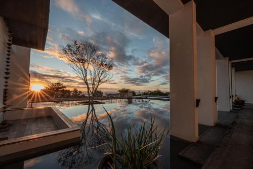 a house with a pool with a sunset in the background at AQUA Tree Resort in Fengbin