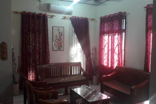 a living room with two benches and red curtains at T'Rai Homestay in Dungun