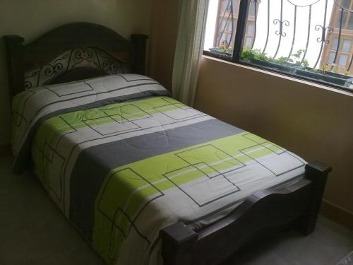 a bed sitting in a bedroom next to a window at Hotel El Parque HR in Fómeque