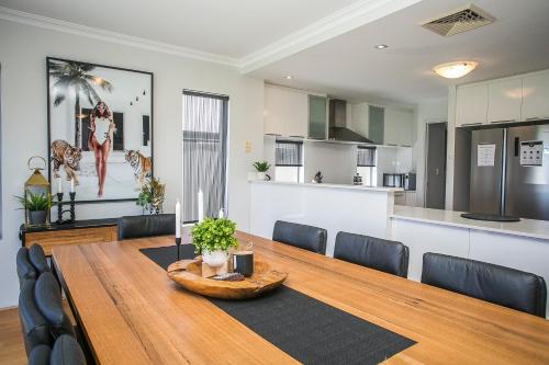 a dining room and kitchen with a wooden table and chairs at CHILLAX HOUSE - Luxury, Canals, Jetty, Family Friendly - Sleeps 14 in Style! in Mandurah