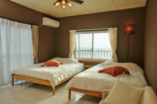 a bedroom with two beds and a window with a view at Vacation House Familia in Kōzushima