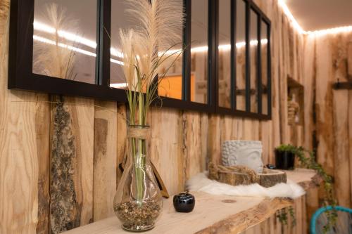 a vase with flowers in it sitting on a table at Gites Aux Fines Bulles d'Alsace SPA privatif en supplément in Bergheim