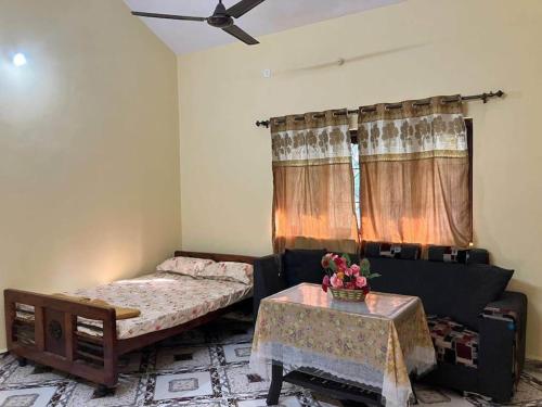 ein Wohnzimmer mit einem Bett und einem Tisch in der Unterkunft Ashpil House Guest House Margao South Goa in Navelim